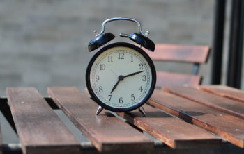 Der Unterschied zwischen wenn und als: Eine Uhr auf einem Holztisch